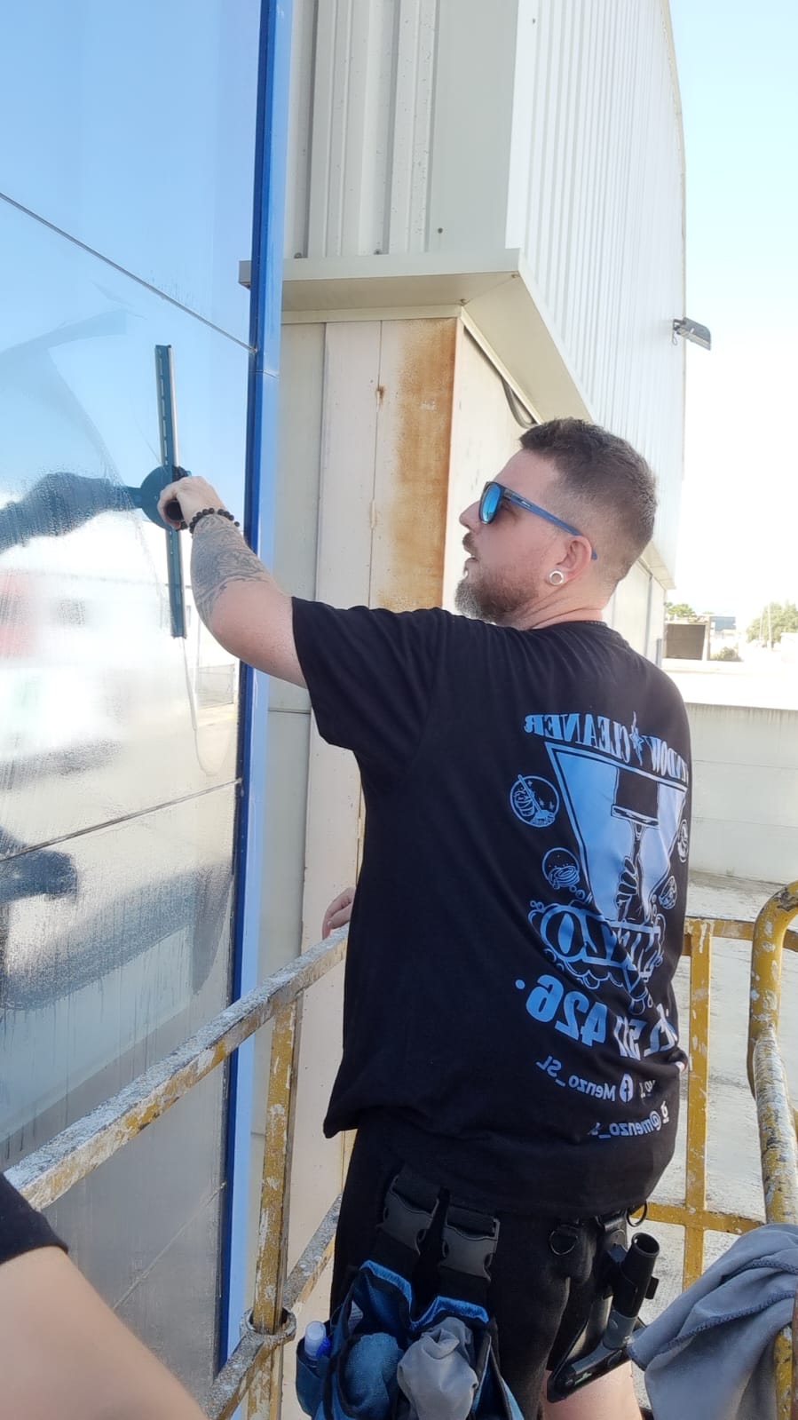 Operario limpiando cristal exterior en altura